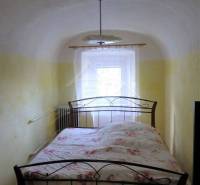 Bedroom with a metal bed and arched ceiling for a family house, cozily styled.