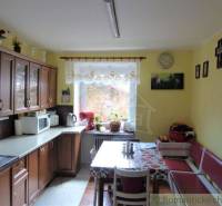 Traditional kitchen with wooden cabinets and a large dining table in a family house.