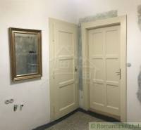 A room with two doors, a golden mirror, ready for renovation. Suitable for a 2-room apartment.