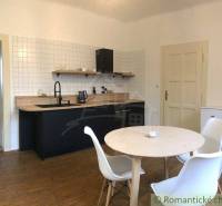A kitchen in an apartment with wooden furniture and a table for a 2-room apartment for rent.