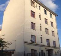 A four-story building with multiple windows offers options for a two-room apartment.
