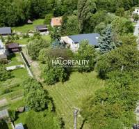 Gardens and family houses in Nová Baňa, surrounded by greenery and trees.