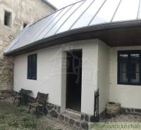 A picturesque cottage with charming stone paving and blue shutters in the shade of a peculiar property.