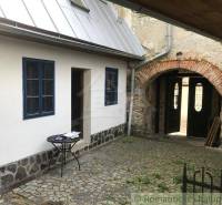 A courtyard of a historic property with a stone arch and a table, ideal for relaxation.