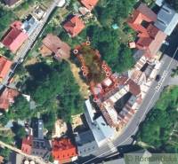 An aerial view shows a peculiar property in a densely built-up area with steep slopes.
