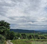 A rural environment with a road, hills, and clouds, suitable for a family house.