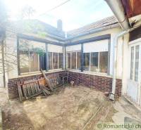 Courtyard of a traditional cottage with wooden doors and windows for romantic cabins.