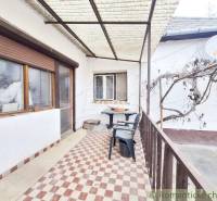 Spacious covered terrace with plastic furniture at the family house.