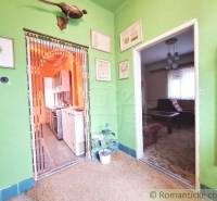Interior of a room in a family house with wall decorations and entrances to the kitchen.