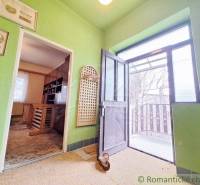 Interior of a family house with open doors to the terrace, green walls, paintings.