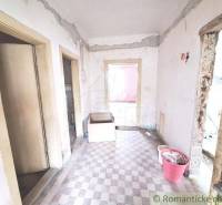 The interior of an unrenovated cottage with worn-out floors and walls, suitable for renovation.