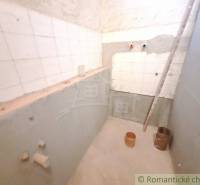 A small cottage with an unfinished bathroom, visible tiles and reconstruction work.