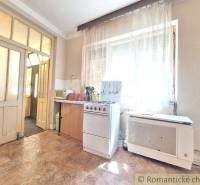 A kitchen in a family house with a gas stove, window, door, curtain.