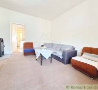 Living room with a stove, sofa, and armchairs in a family house, ideal for family gatherings.