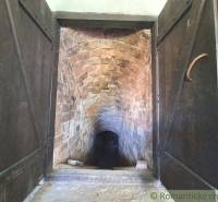 A historic stone tunnel with wooden doors in a peculiar property.