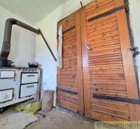 An old tiled stove and wooden doors in a rustic room, Unique properties.