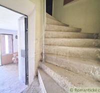 Interior with concrete stairs and a bright room underneath them. Unique real estate.