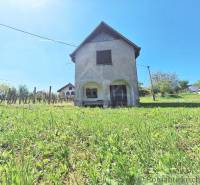 A building on a slope with grass and fencing in the city of Komárno, peculiar properties.