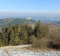 Snow-covered landscape, forest, stunning view of rocks, and visible nature around.