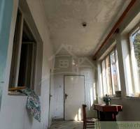 A place in a rural family house with a hallway and a sewing machine by the window.