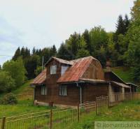 A cottage in Veľké Rovné, surrounded by greenery and forest, simple architecture.