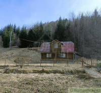 A wooden cabin in the mountains, surrounded by coniferous trees, ideal for relaxation in nature.