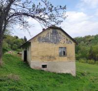 An old cottage with damaged plaster in a picturesque natural setting, an ideal family home.