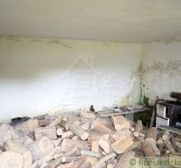 A pile of wood and an old stove in the room of an old family house cottage.