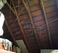 The attic of a family house with an old wooden roof structure and hanging ropes.