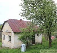 A family house on a hill with trees and a meadow in the background, ideal for nature.