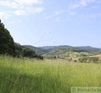 Beautiful nature with hills, valleys, and a family house on the horizon, ideal for relaxation.