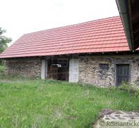 Stone cottage with a red roof on the grass, traditional family house.