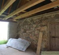 Interior of a building with a stone wall, wooden ceiling, and concrete floor. Family house.