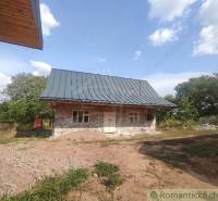 Stone family house with a sloped roof in the middle of a natural environment.