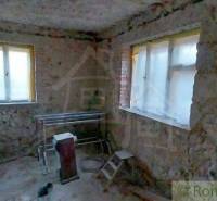 Interior of a house with stone walls, windows, and built-in equipment. Family house for renovation.