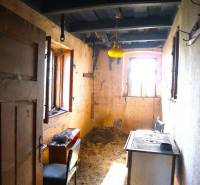 An abandoned family house with a simple kitchen and old appliances, it has a historical feel.
