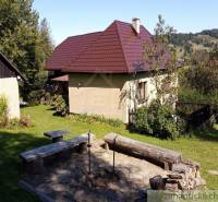 A family house with a wooden fence in the countryside, surrounded by nature and greenery.