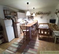 Rustic kitchen in a family house with wooden furniture, decorations, and open shelves.