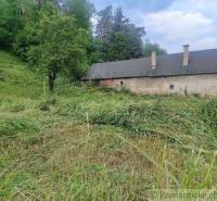 A rural building surrounded by grass and trees, ideal for living on large plots.
