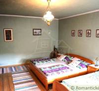 A bedroom with wooden beds and furniture in a traditional cottage: cozy atmosphere and decorations.