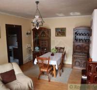 The living room with wooden furniture and a tiled stove fits charmingly into the atmosphere of the cottage.