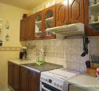 Rustic kitchen with wooden cabinets, a kitchen stove, and decorations suitable for cottages.
