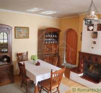 Dining room and cozy cabin with a fireplace, wooden furniture, and an ornamental chandelier.