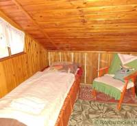 A room in a cottage, wooden interior, bed, chair, cozy atmosphere.