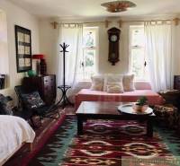 A living room in a family house with rustic furniture and a colorful carpet.