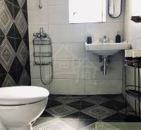 A family house bathroom with geometric tiling, a sink, and a toilet. Stylish design.