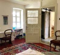 Room with carpet, antique furniture, simple chairs, and a family house.