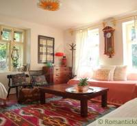 Cozy living room with a patterned carpet, furniture, and a clock in a family house.