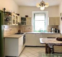 A kitchen with a retro touch, furniture, a chandelier, and a dining table in a family house.