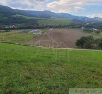 Idyllic landscape with fields surrounded by hills and gardens, peaceful atmosphere of nature.